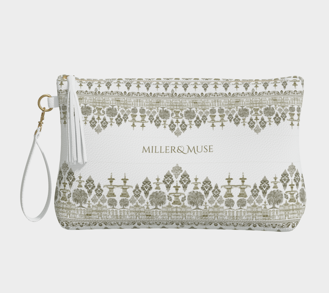 A hand-drawn damask style print pebble textured cosmetic case with the text 'MILLER&MUSE' on the front, featuring iconic architecture and natural scenery of Savannah, Georgia like the forsyth fountain and the savannah cotton exchange building. The cosmetic case has a wristlet, gold metal zipper, and white tassel attached to the zipper.