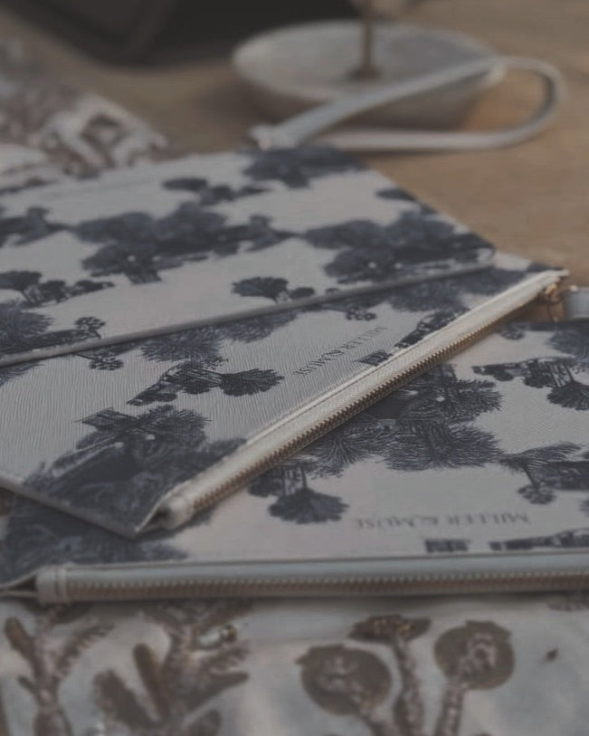 Up-close image of blue and white toile printed wallets and clutches on a table display in Beaufort,SC.